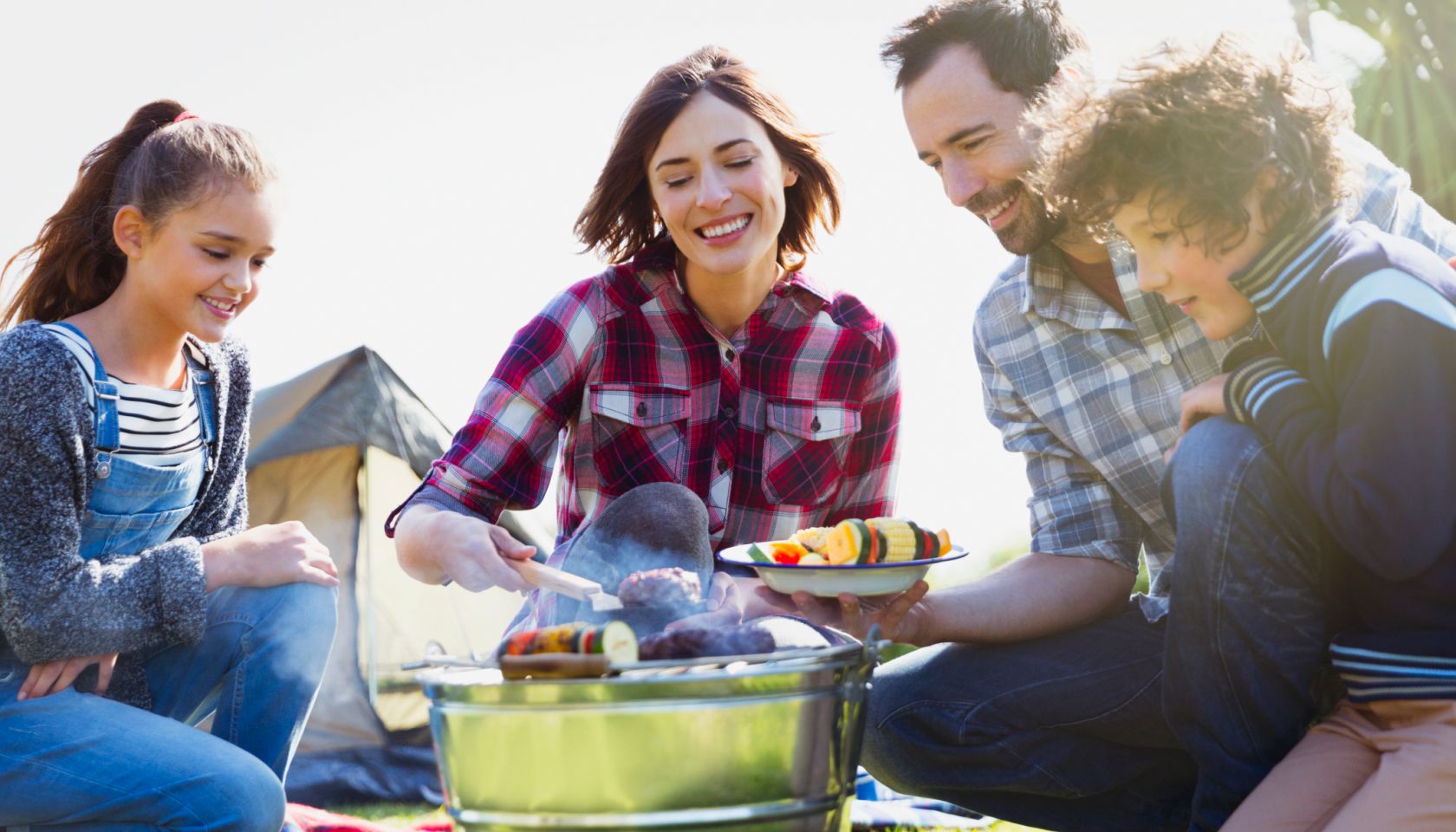 Family barbecuing at campsite grill
