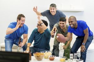 A group of guys watching American Football together and having a party.
