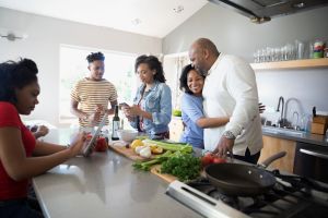 Affectionate African American family cooking in kitchen