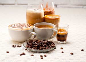 Close-Up Of Coffees With Roasted Coffee Beans Served On Table