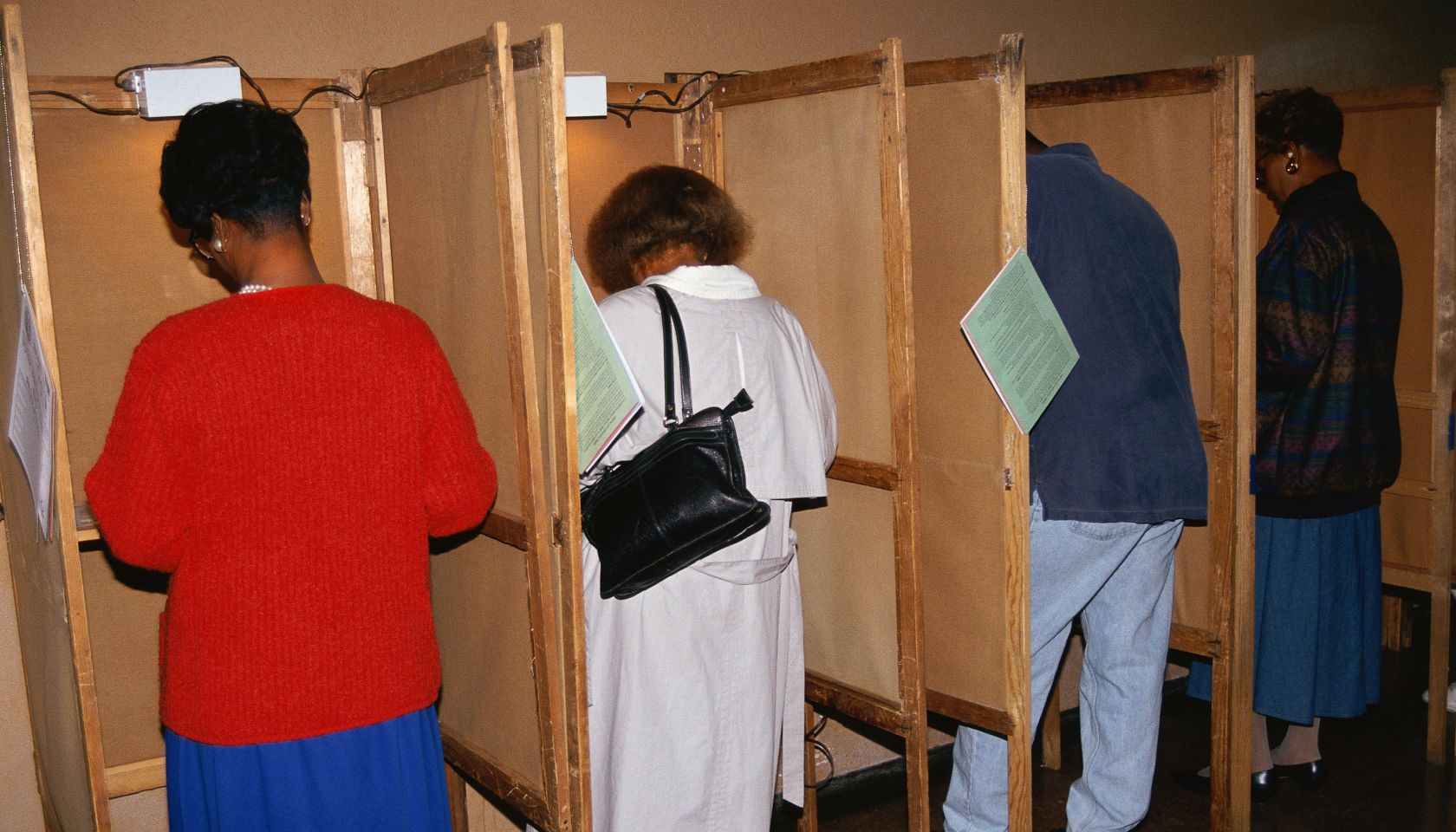 Voters selecting candidates in voting booths