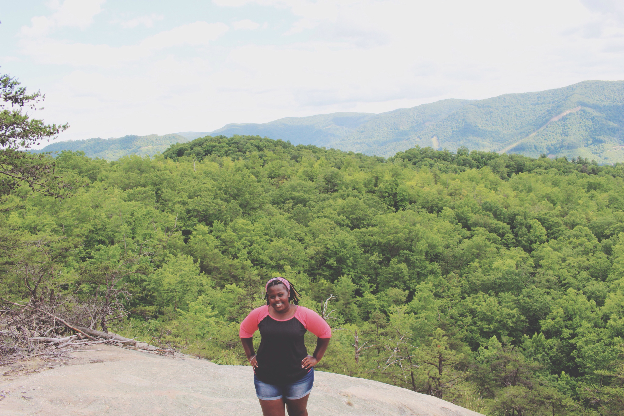 Portrait Of Woman With Hands On Hip Standing On Mountain Against Trees