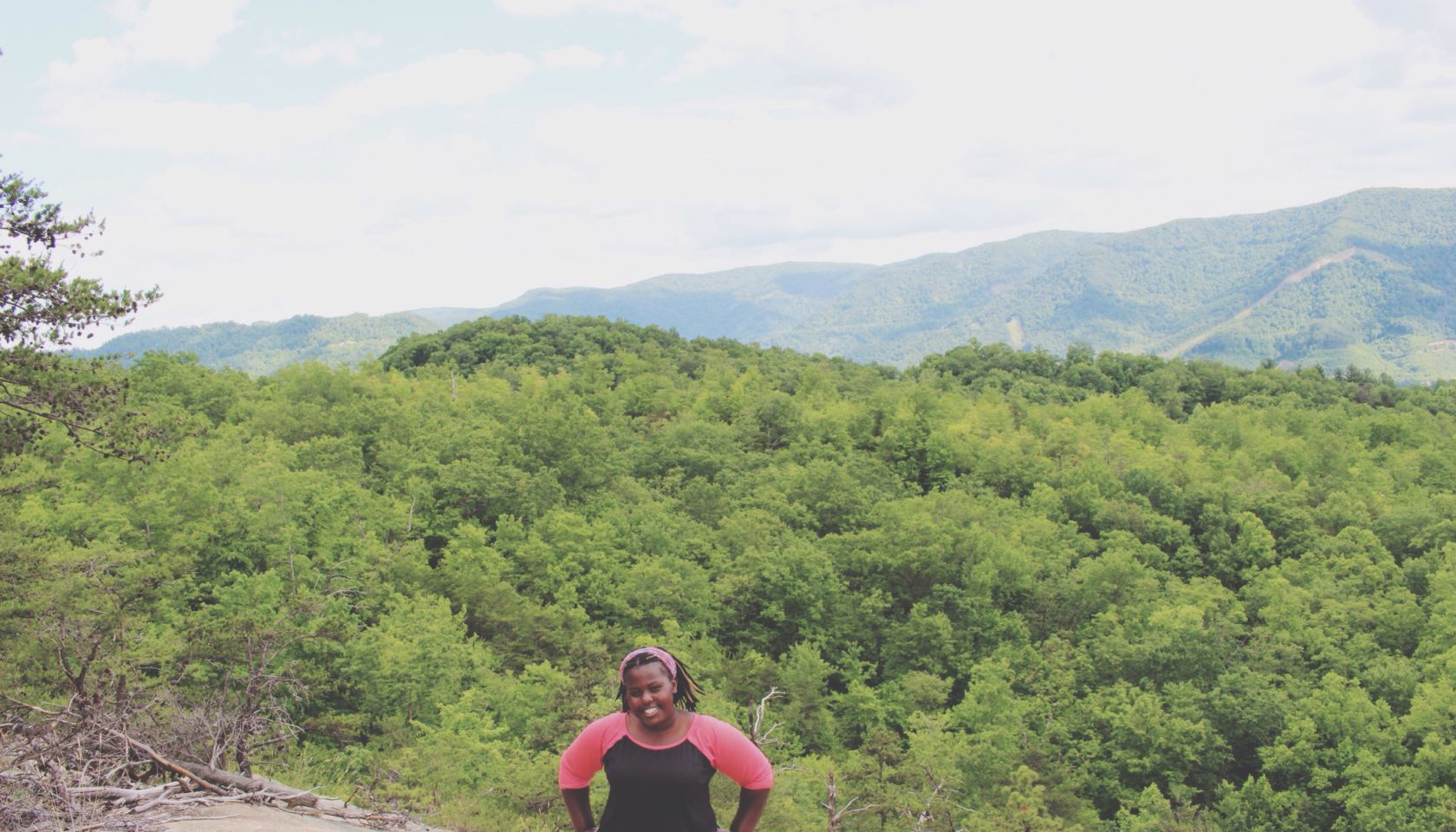 Portrait Of Woman With Hands On Hip Standing On Mountain Against Trees