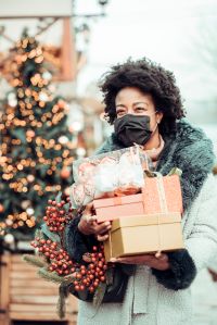Woman at Christmas shopping, COVID-19 pandemic. She wearing a protective mask to protect from corona virus COVID-19