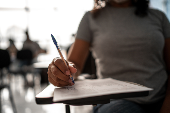 Female hands of a student taking a test