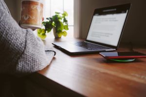 Woman Sips on Coffee While Working at Desk