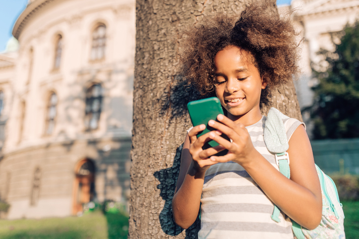 Girl using a smartphone in the park after school