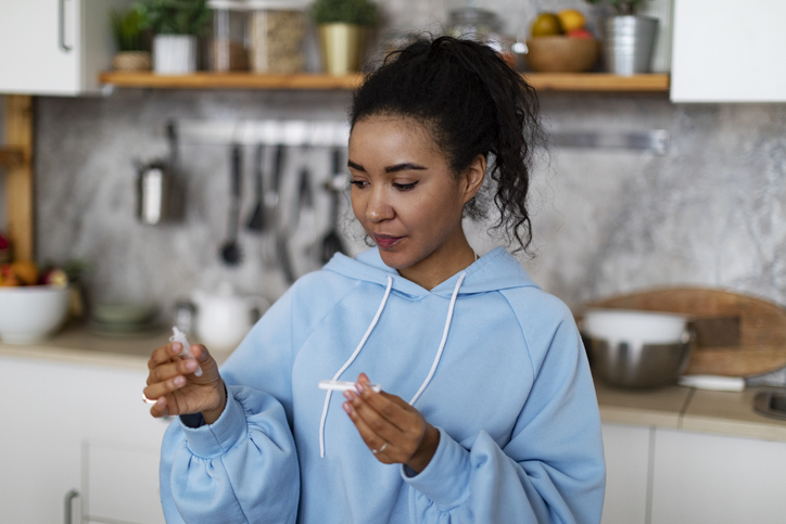 Young African woman making rapid test for covid-19 at home