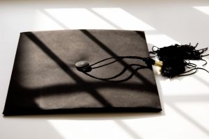 single black graduate cap on white background with shadow detail