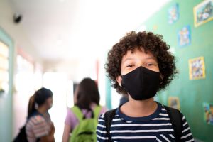 Portrait of a boy in the corridor at school - wearing protective face mask