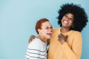 Candid photo two female friends laughing together