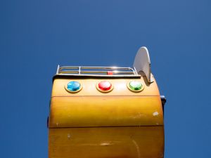 Low Angle Colour Shot Of A 1950S Style Fairground Car Against A Clear Blue Sky