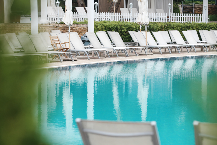 Empty Swimming Pool Public Area With White Tanning Beds On a Sunrise Moment