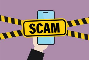 Hand holds a mobile phone with a scam sign