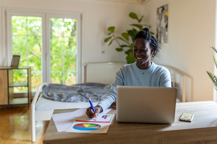 Modern female student Black ethnicity using laptop, while studying from her college dorm