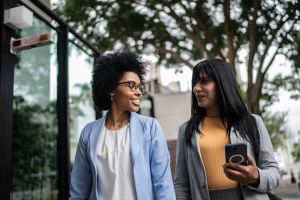Business women talking while walking outdoors