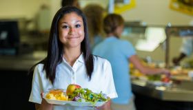 Happy African American high school girl in school cafeteria
