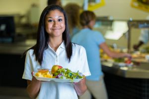 Happy African American high school girl in school cafeteria