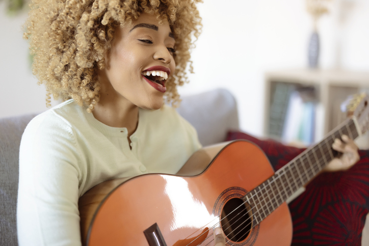 Woman Playing Acoustic Guitar at Home