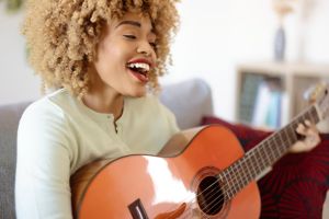 Woman Playing Acoustic Guitar at Home