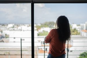 Mid adult woman looking away contemplating at home