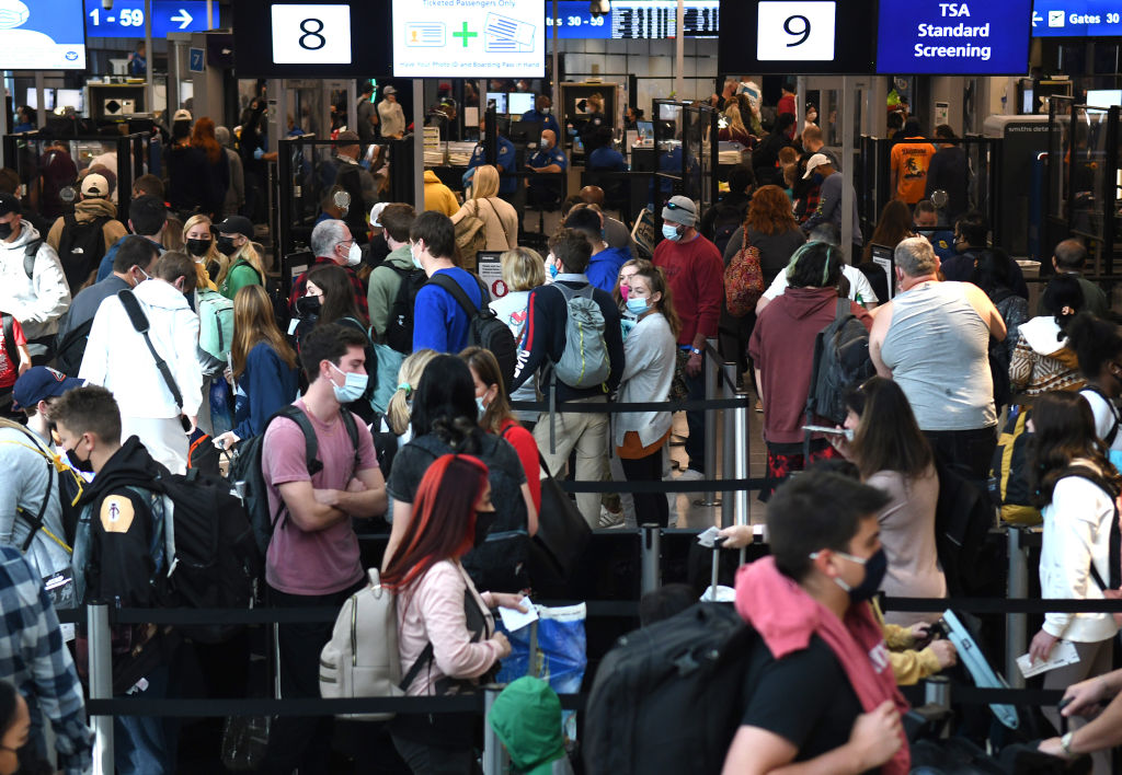 People are seen in a TSA security checkpoint line at Orlando...