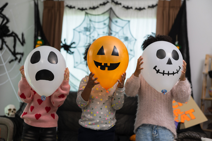 Happy Caucasian white and African America children getting halloween party in their house.