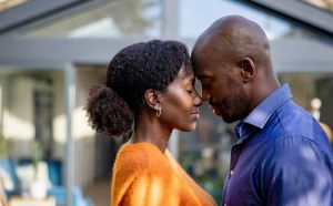 Loving black couple in front of their new house