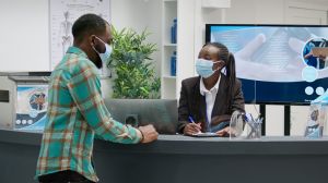 Diverse group of patients with face masks sitting in hospital reception