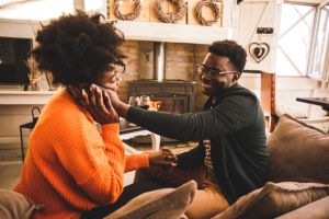 Caring young man caressing his girlfriend's face while they are having romantic, bonding moments