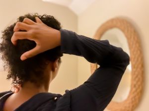 mid adult african-american woman runs fingers through wet natural hair