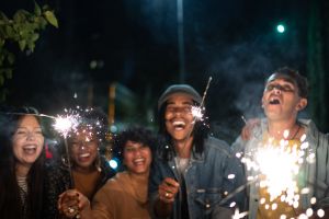 Friends celebrating with sparkers in the street at night