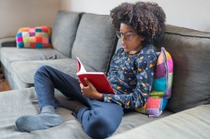 Cute boy in glasses reading a book