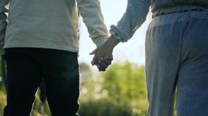 Loving african ethnicity couple walking down the park. Holding hands together