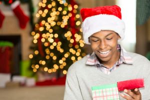 Cute teen boy opens gift on Christmas day