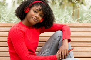 woman with headphones sitting looking at camera