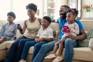 African American family watching tv at home