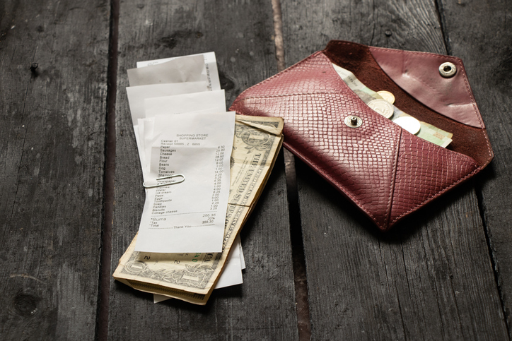 a check from the supermarket with dollars lies a cough with money on a wooden table in the light at home, money on the table