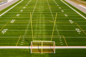 Soccer field grass view. Football field with green grass and white paint lines and marks. Sports soccer and football with nice green environment. Recreational activity ground.