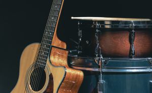 Acoustic guitar and snare drum on a black background isolated.