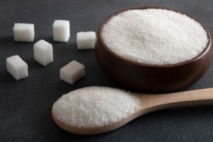 Cube sugar and granulated sugar on dark background