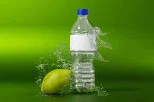 Mockup of bottle with splash water and lemon on green background. white blank label. Water bottle advertising. 3d illustration