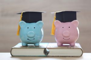 Graduation hat on piggy bank and a books on white background, Saving money for education concept