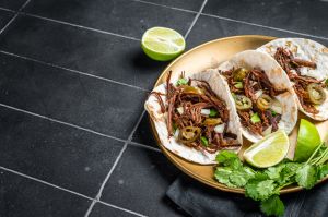 Mexican Beef Barbacoa Tacos with Cilantro and Onion. Black background. Top view. Copy space