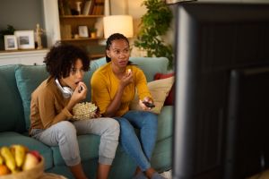 Mother and son watching scary movie on TV at home