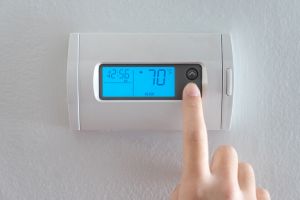 Hand press indoor room thermostat to lower the temp