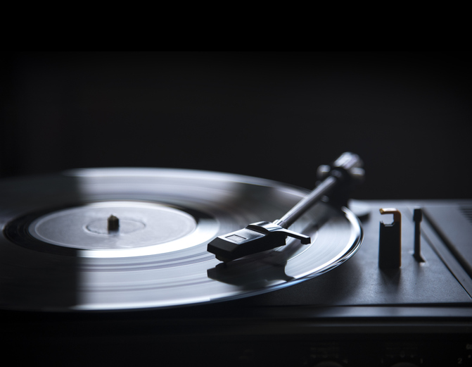 Retro gramophone vinyl player over black background with copyspace.