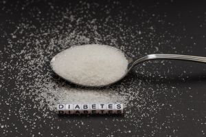 White crystal sugar on a small spoon with the inscription diabetes. Campaign to reduce sugar consumption.