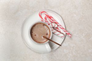Christmas chocolate milk mug with candy cane stick, concept of winter holidays desserts and decoration