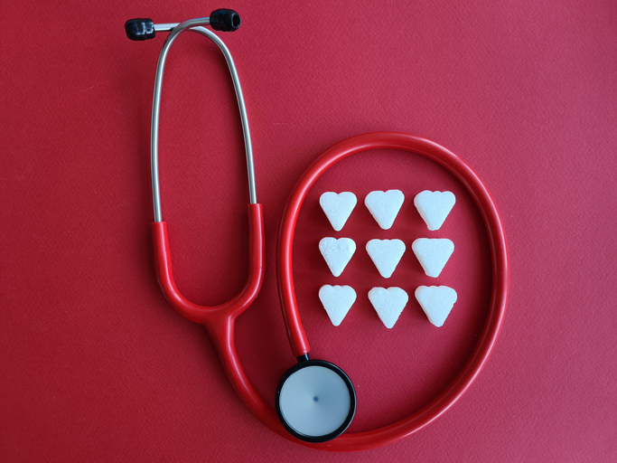 Stethoscope With White Hearts on Red Background
